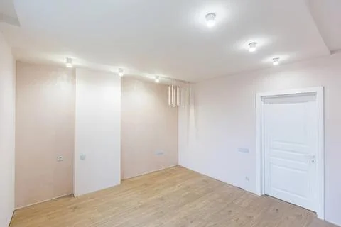 Empty bright room with white walls and wooden floor Stock Photos