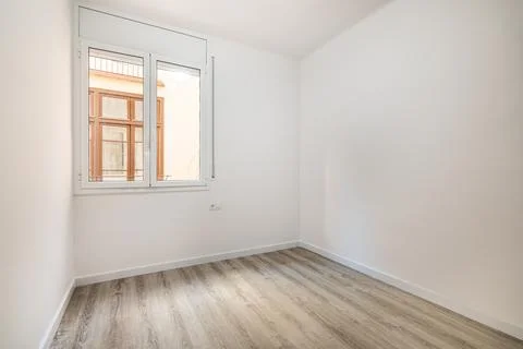 An empty bright room with a window in which the windows of a nearby house are Stock Photos