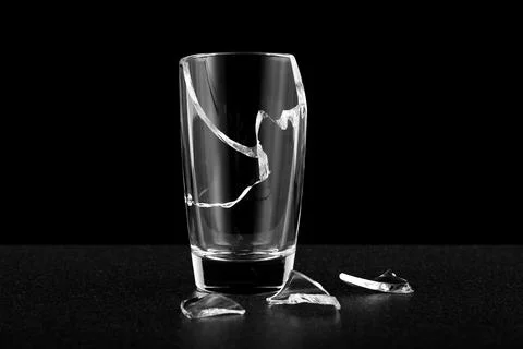 An empty broken glass without liquid, fragments of cracks along the body Stock Photos