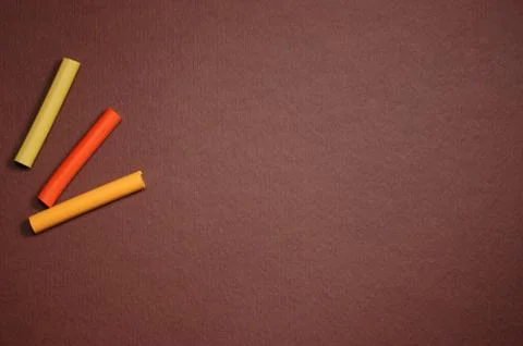 Empty brown cardboard background and multicolored pastel - art utensil Stock Photos