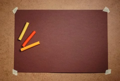 Empty brown cardboard background and multicolored pastel - art utensil Stock Photos