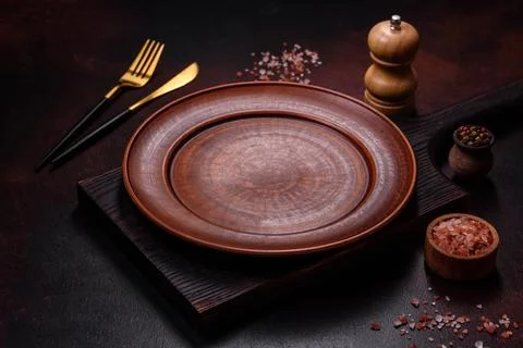An empty brown ceramic plate on a dark concrete brown background Stock Photos