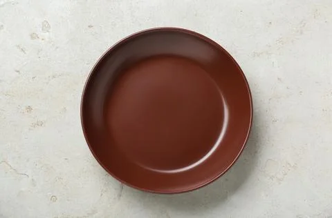 Empty brown ceramic plate on light grey table, top view Stock Photos