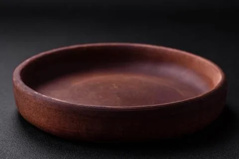 Empty brown colored ceramic plate on dark concrete background Stock Photos