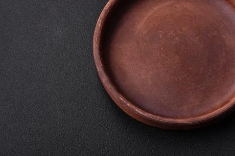 Empty brown colored ceramic plate on dark concrete background Stock Photos