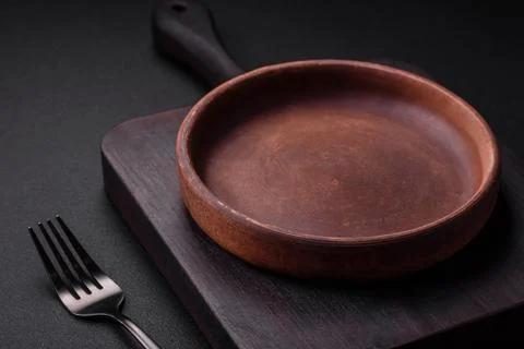 Empty brown colored ceramic plate on dark concrete background Fotos Stock