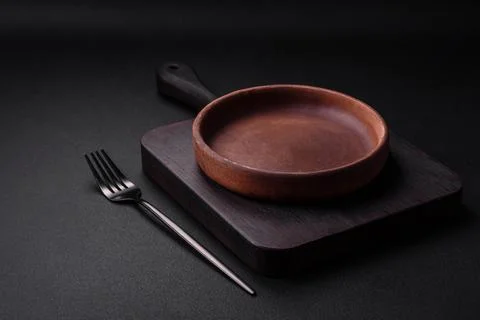 Empty brown colored ceramic plate on dark concrete background Stock Photos