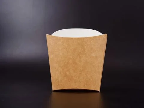 Empty brown paper cup on black surface with dark background Stock Photos