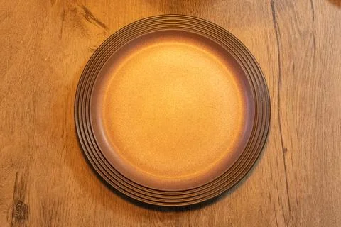 Empty brown plate on rustic wooden table copy space for text Stock Photos