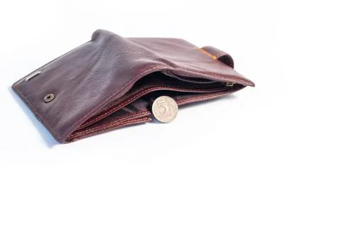 An empty brown wallet with a five-ruble coin next to it. On a white backgroun Stock Photos