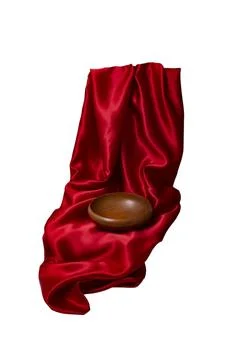 Empty brown wooden bowl on red satin fabric folds, isolated on white backgr.. Stock Photos
