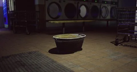 Empty bucket in a dimly lit laundromat during late night hours Stock Illustration
