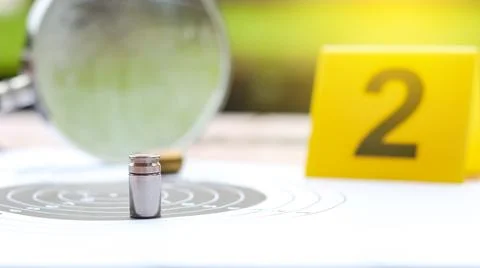 Empty bullet casing on a shooting target, with blur part of magnifying glas.. Stock Photos