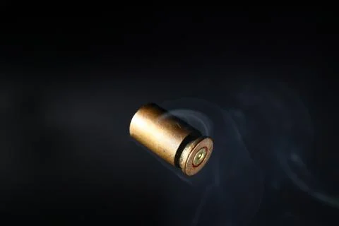 Empty bullet shell casings, on a black background, smoke Stock-Fotos