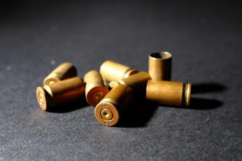Empty bullet shell casings, on a black background, smoke Stock-Fotos
