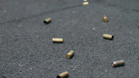 Empty bullets fall on the floor on shooting range. Sport shooter police training Stock Footage 257085457