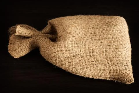 Empty burlap or burlap sack isolated on dark background. Front view, design e Stock Photos