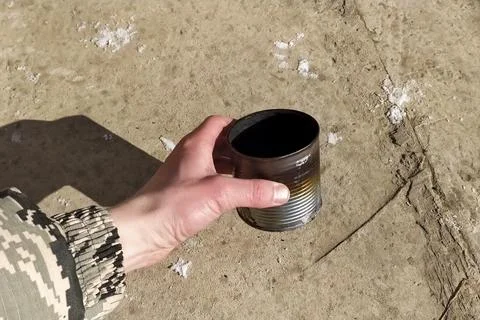An empty burnt tin can in the hands of man Stock Photos