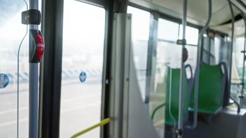 Empty bus interior with green seats and a stop button on a pole, showcasing.. Stock Footage 302502449