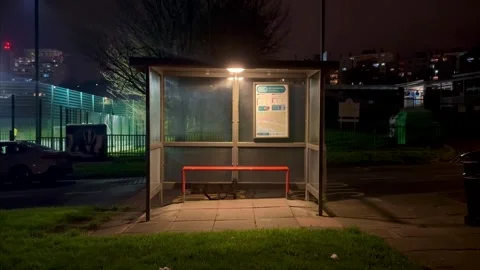 Empty bus stop at night with car driving past Stock Footage 330011386