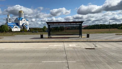 Empty bus stop shelter near white orthodox church with blue roof  Vídeo Stock 343406859