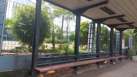 Empty Bus Stop Shelter with Wooden Bench and Metal Frame Outdoors Stock Footage 317536119