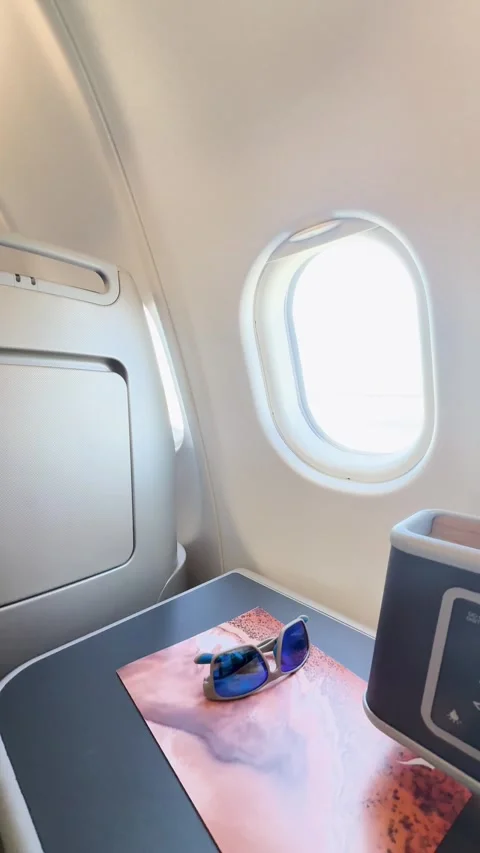 Empty Business Class Airplane Seat with Sunglasses and Travel Magazine Stock Footage 327830906