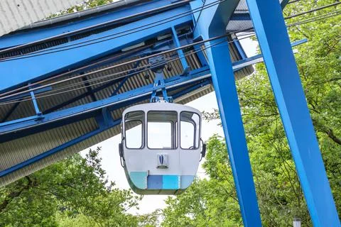 Empty cabin hanging from cable car on huge metal structure Foto stock