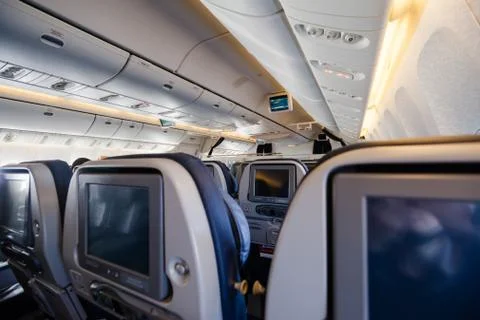 Empty cabin of a large aircraft with rows of seats Stock Photos