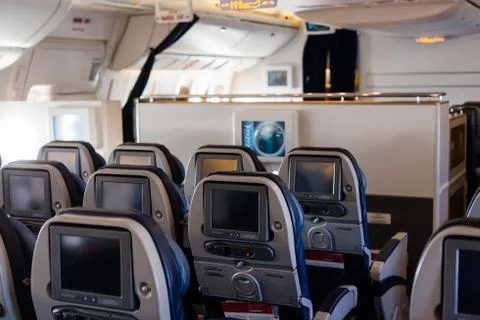 Empty cabin of a large aircraft with rows of seats Stock Photos