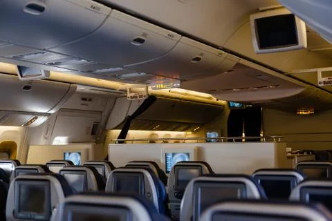 Empty cabin of a large aircraft with rows of seats Stock Photos