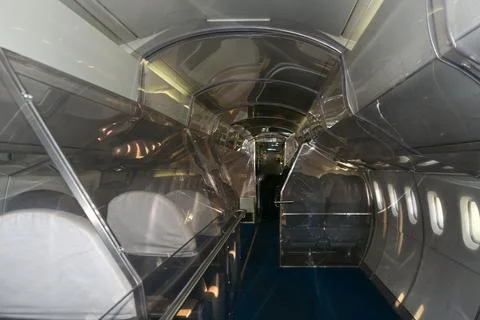 Empty cabin of a passenger plane from the inside with rows of seats Stock Photos