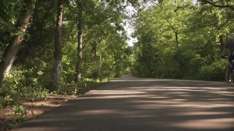 Empty calm asphalt cement pavement road fot bicycle sport bike through the green Stock Footage 132672527