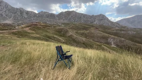 Empty Camping Chair Overlooking Mountain Landscape with Sheep Stock Footage 343830459