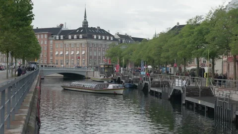 Empty canal tour boat maneuvers to dock at Gammel Strand pier in Copenhagen Stock Footage 345500025