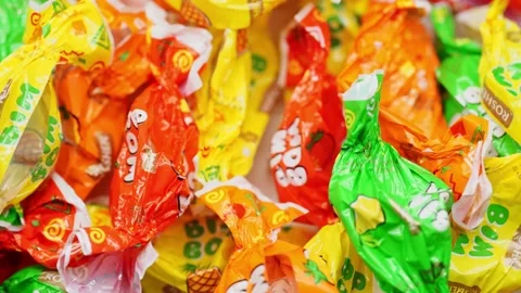 Empty candy wrappers rotate in a circle Stock Footage 234997536