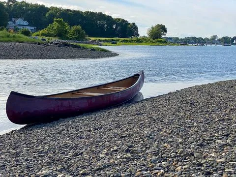 Empty canoe sitting on the water's edge Stock Photos