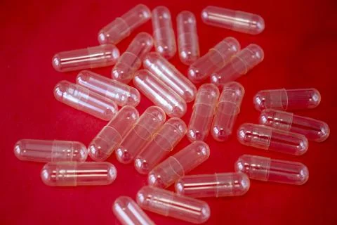 Empty Capsule Pill on a Bright Red Background Stock Photos