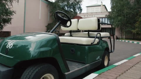 Empty car golf course outside. Golfing buggy tires wheels stand on grass parking Stock Footage 219610434