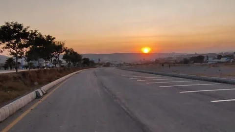 Empty car parking at sunset and other side traffic is running Stock Footage 300011324