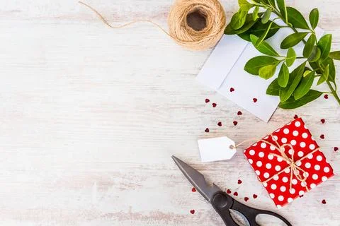 Empty card tied on red dotted gift box over white wood background. Copy spa.. Stock Photos