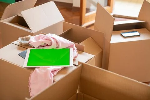 Empty cardboard boxes ready to be open along with a tablet with green screen, 写真素材