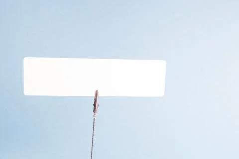 Empty cardboard plate, empty white place for your text, clothespin on the spr Stock Photos