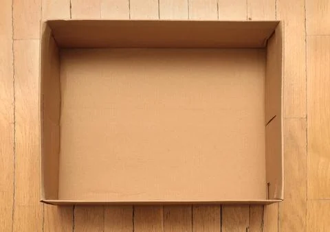 Empty cardboard rectangle box on wooden floor 스톡 사진