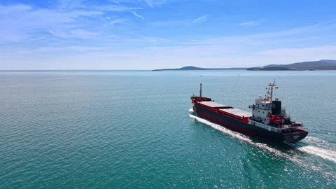 Empty cargo ship in a voyage. Following a carrier bulk going by the calm Stock Footage 334932235