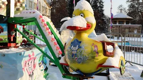 The empty carousel is covered with snow. Close up of snow covered colorful du Stock-Fotos