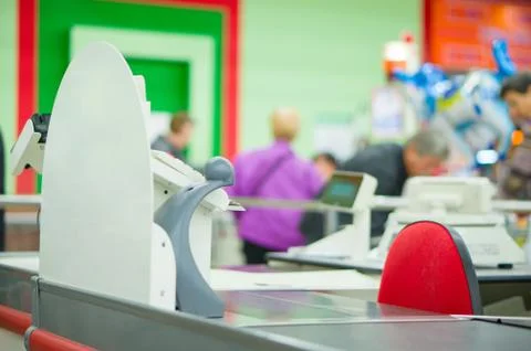 Empty cash desk and queue of customers on back in supermarket Stock Photos