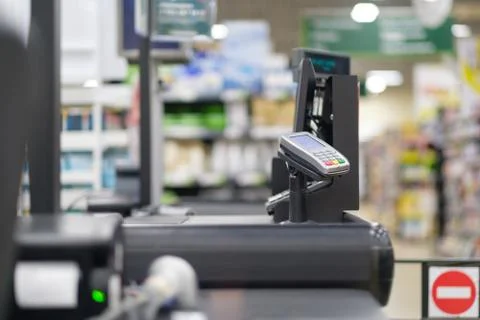 Empty cash desk with computer screen and card payment terminal on blurry ba.. Stock Photos