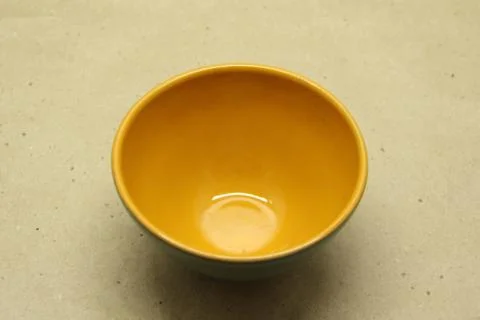 Empty ceramic bowl without a handle on a beige background Foto stock