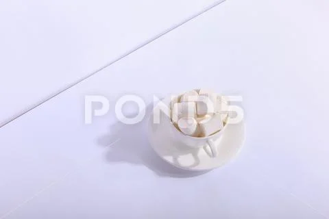 Empty ceramic cup with marshmallows on a saucer, on a white background. Hard Stock Photos